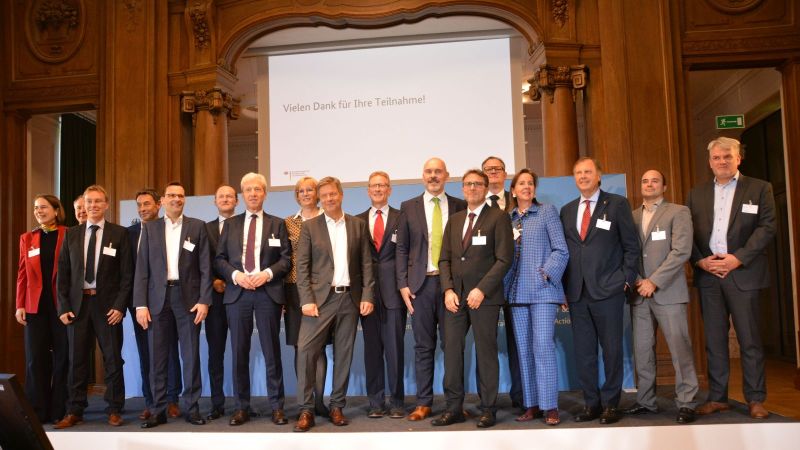 Gruppenfoto von allen Unternehmensvertretern, die einen Klimaschutzvertrag erhalten haben und Robert Habeck, die gemeinsam auf einer Bühne stehen.